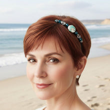 Load image into Gallery viewer, Woman wearing headband with a dolphin centerpiece and blue beads on a beach