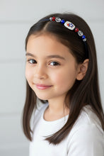 Load image into Gallery viewer, girl wearing flexible headband side-embellished with patriotic stars, red, white and blue stars centerpiece, accented with red, white, blue crystal beads, Red White Blue Stars Headband
