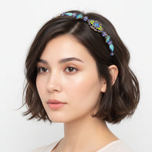 Load image into Gallery viewer, woman wearing a side-embellished headband with cloisonné style enameled beads and lilac colored sparkly Austrian crystal beads on a white background
