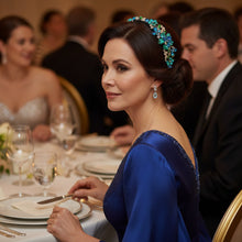 Load image into Gallery viewer, Woman wearing jeweled camellia headband with blue and green floral design.
